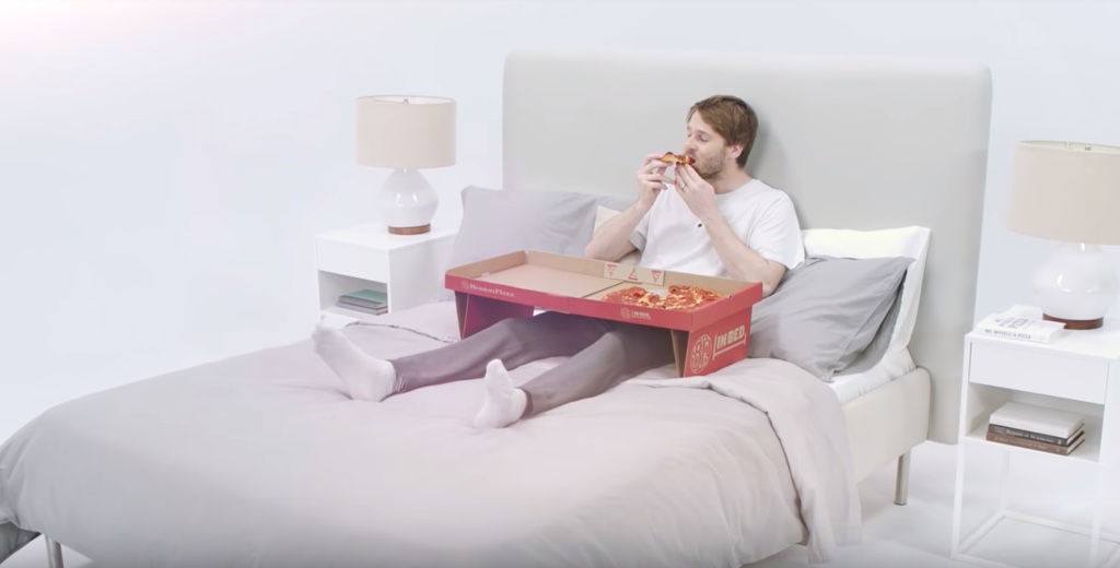 Pizza Karton lädt zum Essen im Bett ein